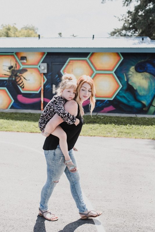 Working mom piggybacks her young daughter in Kamloops, British Columbia