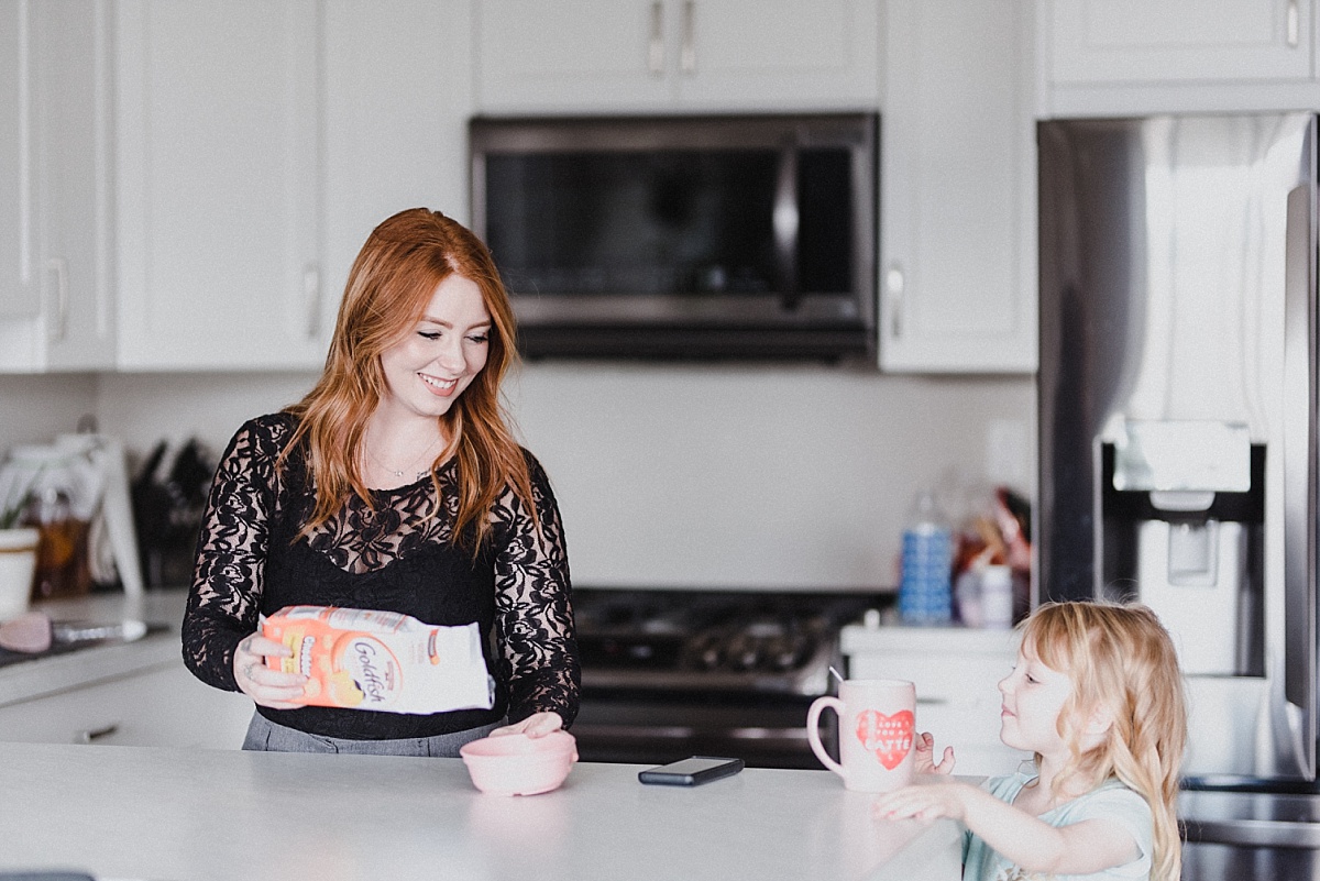 Skyleigh McCallum, Kamloops Realtor and Financial Educator, pouring Golfish crackers in a bowl for her daughter; financial planning tips for parents