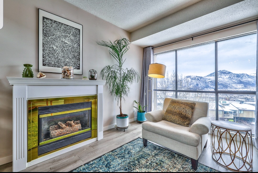 Elegant living room with a fireplace and a view of snowy mountains, for those buying a home in Kamloops