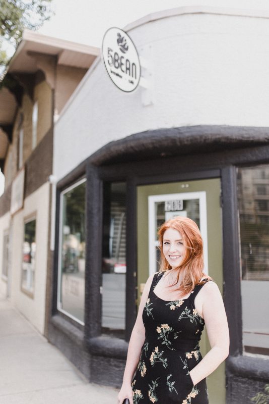 Skyleigh McCallum, Kamloops Realtor and financial educator with WFG, stands in front of 5Bean while smiling at the camera.
