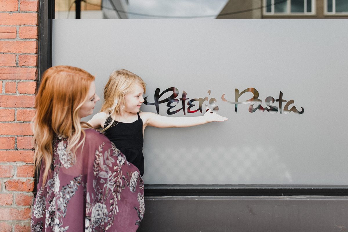 Skyleigh McCallum Kamloops Realtor and her daughter standing in front of Peter's Pasta, a restaurant in downtown Kamloops.