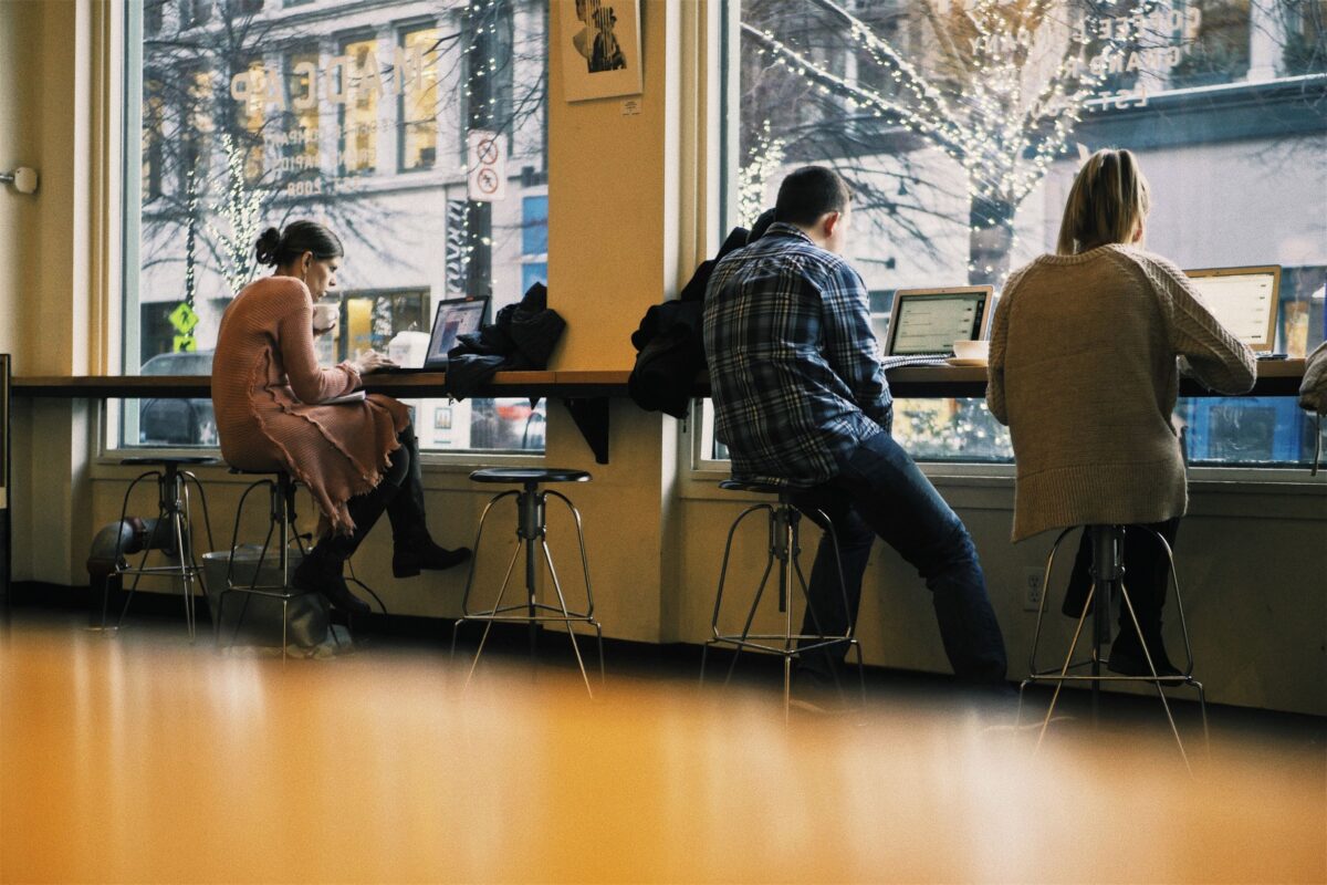 Generation Z embraces the side hustle, working on laptops in a coffee shop.