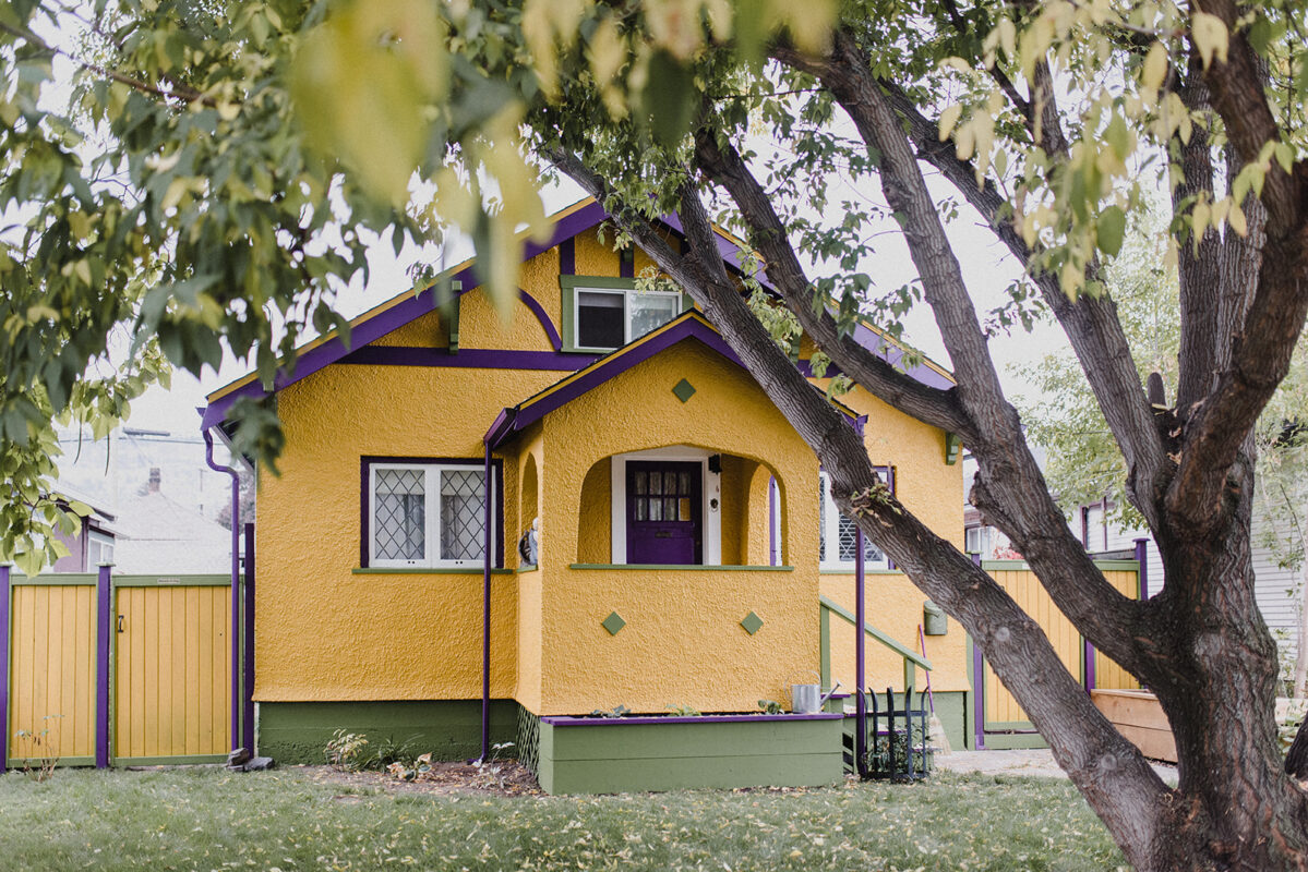 An adorable yellow character home in the Kamloops real estate market with purple trim.