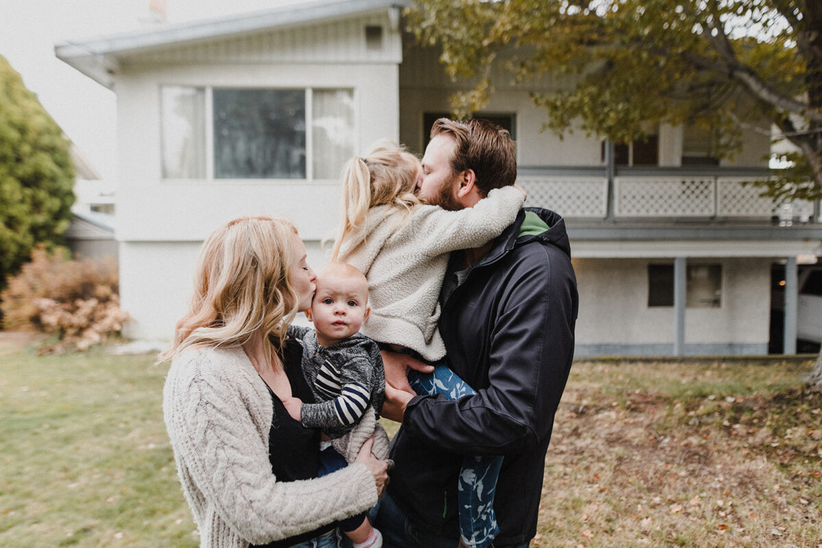 Kamloops Realtor Skyleigh McCallum stands with her family in front of a new home they purchased because the Kamloops real estate market is booming.