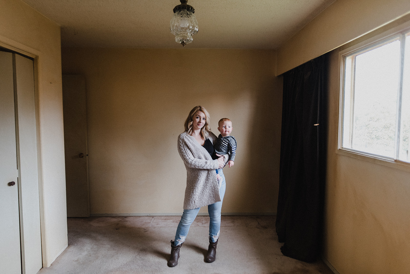 Skyleigh McCallum, Kamloops Realtor and financial educator, standing in her recently purchased home while holding her son.