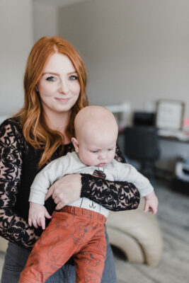 Skyleigh McCallum holds her baby and smiles while reflecting on the success she's had reaching her goals