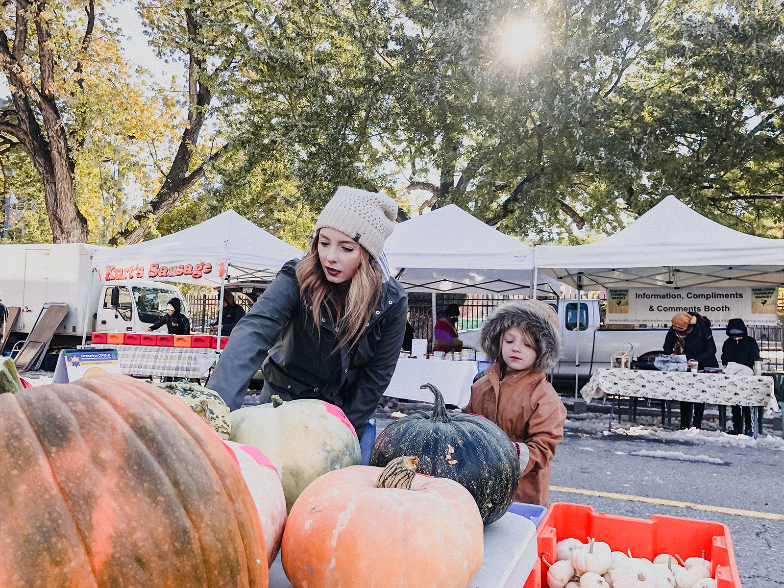 Skyleigh at the Kamloops farmers market picking out pumpkins with her daughter